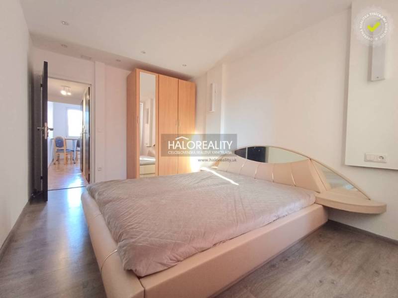A bedroom with a built-in wardrobe, bed, and wooden decor flooring in a 3-room apartment.
