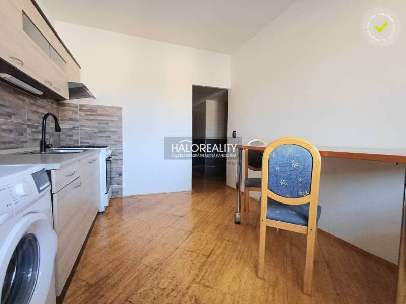 A kitchen in a 3-room apartment with a wooden decor floor and a dining table.