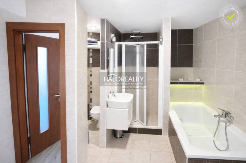 A bathroom with a bathtub and a shower in a 3-room apartment.