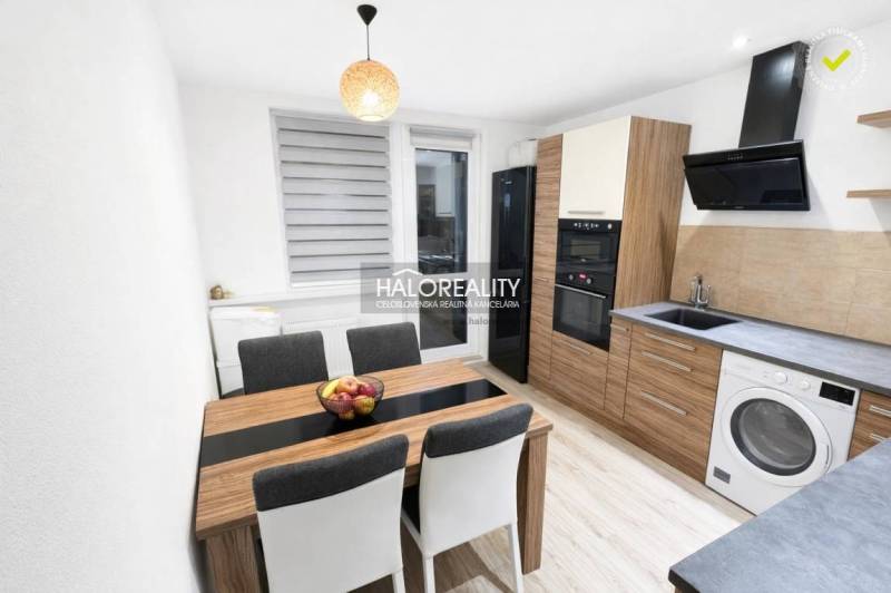 A kitchen in a 3-room apartment with a wooden decor floor and modern furnishings.