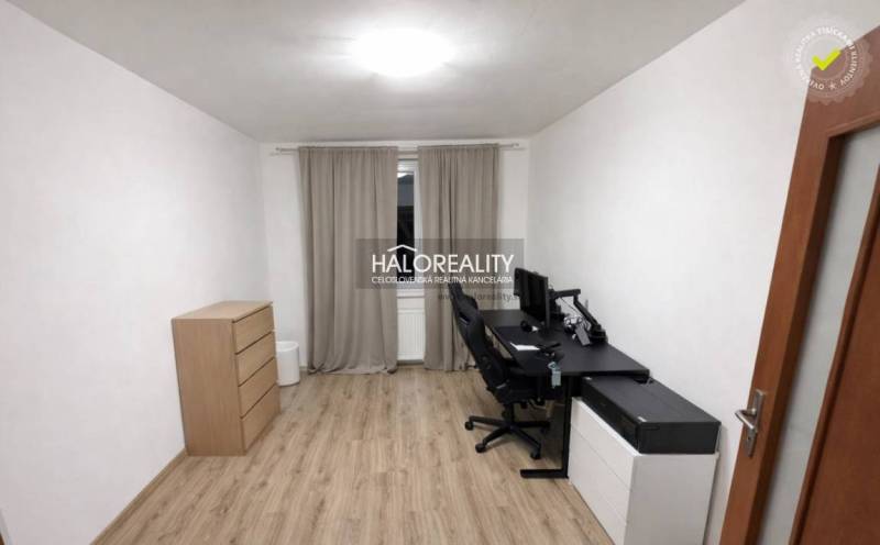 A study in a 3-room apartment, with a wooden decor floor, a desk, and drawers.