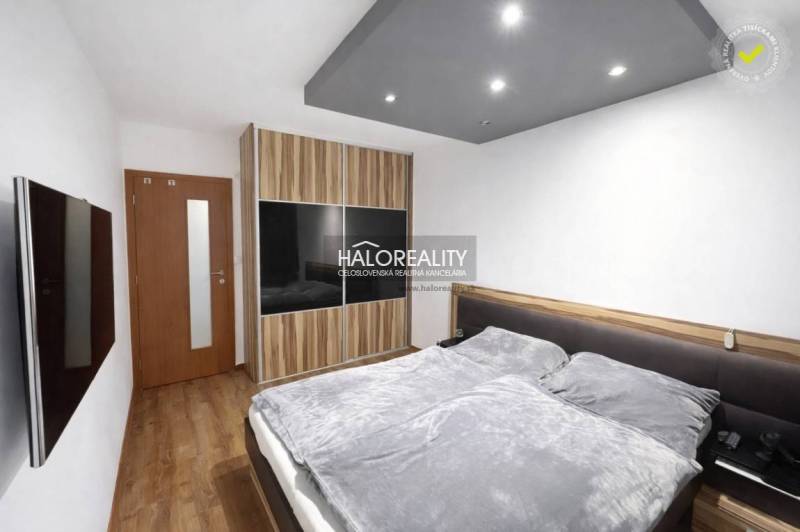A bedroom with a wood-patterned floor and a built-in wardrobe in a 3-room apartment.