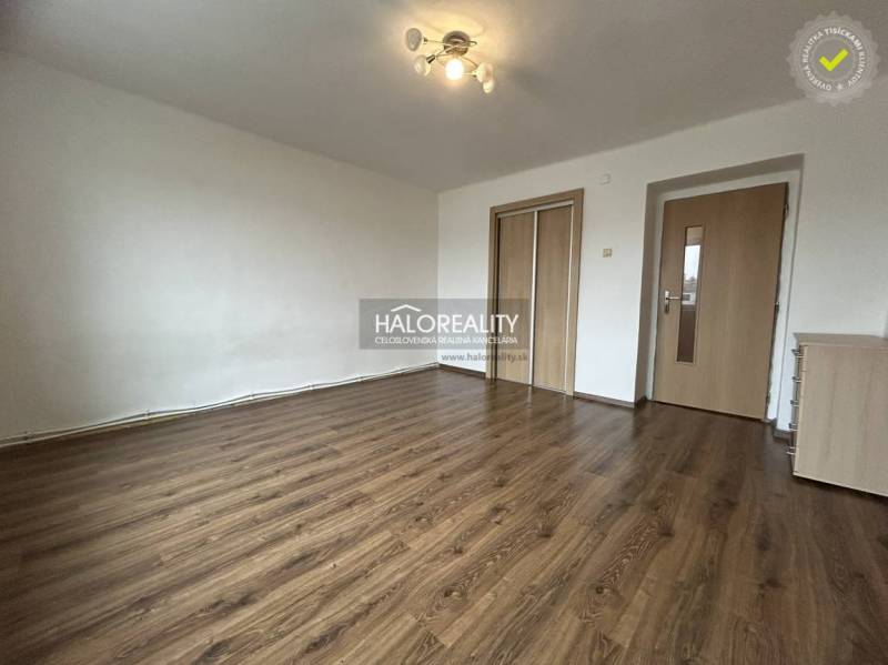 A bright interior in a 2-room apartment with wood-patterned flooring and white walls.