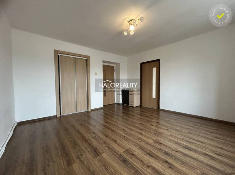 Living room in a two-room apartment with a wooden decor floor and a built-in wardrobe.