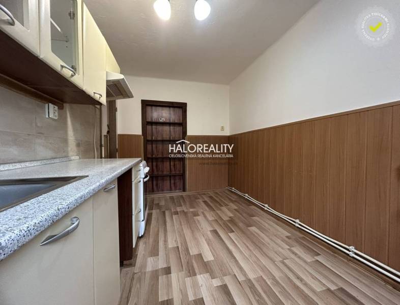 A kitchen with a wooden decor floor in a 2-room apartment.