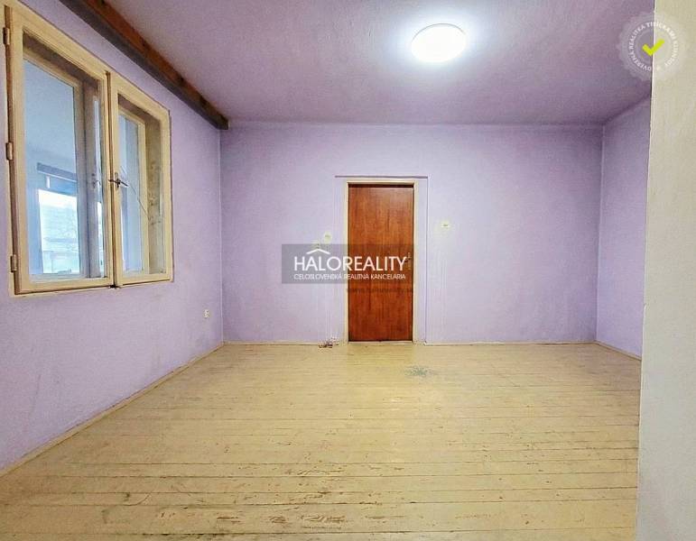 A room in a family house with purple walls and a wooden decor floor.