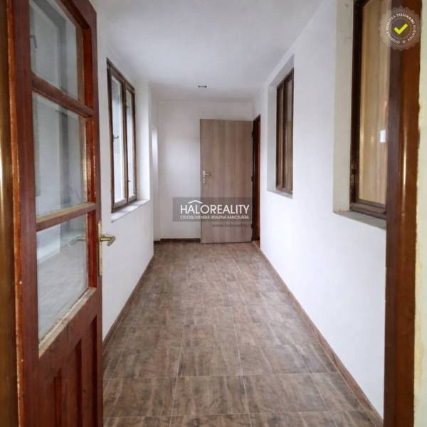 A hallway with light walls and a wooden decor floor in a family house.