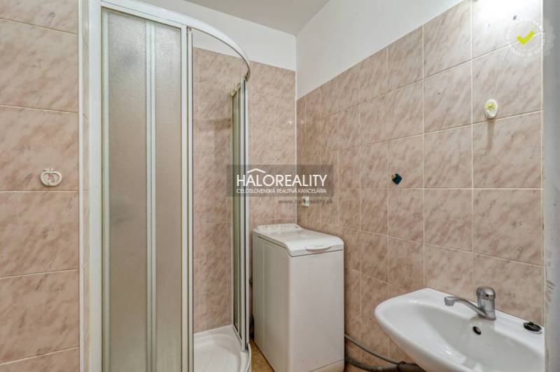 Bathroom in a 2-room apartment with a sink, shower, and washing machine.