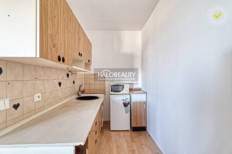 Kitchen in a 2-room apartment with wooden decor, cabinets, and refrigerator, interior.