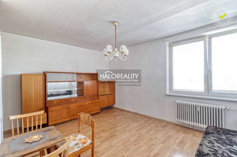 A room in a 2-room apartment with older furniture and a floor with a wood decor.