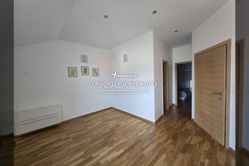 Interior of a holiday apartment with wood-patterned flooring and white walls.