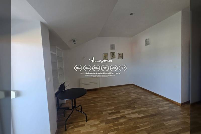 A room in a recreational apartment with a wooden decor floor, a table, and a shelf.