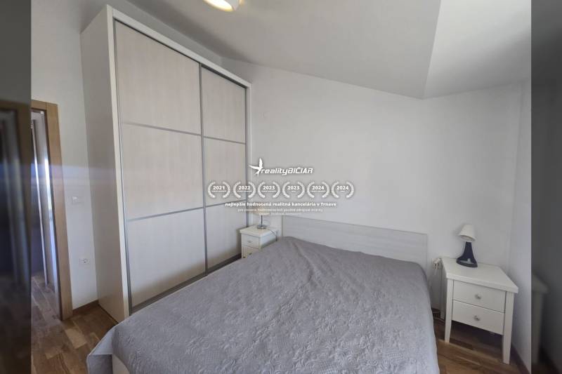 A bedroom of a holiday apartment with a large wardrobe and a wooden decor floor.