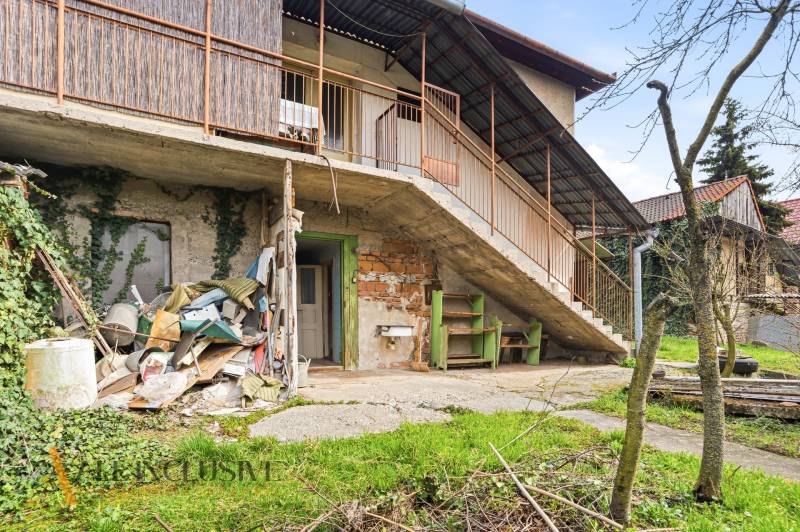 A family house in Malá nad Hronom with an external staircase and a garden, with stored items on the ground floor.