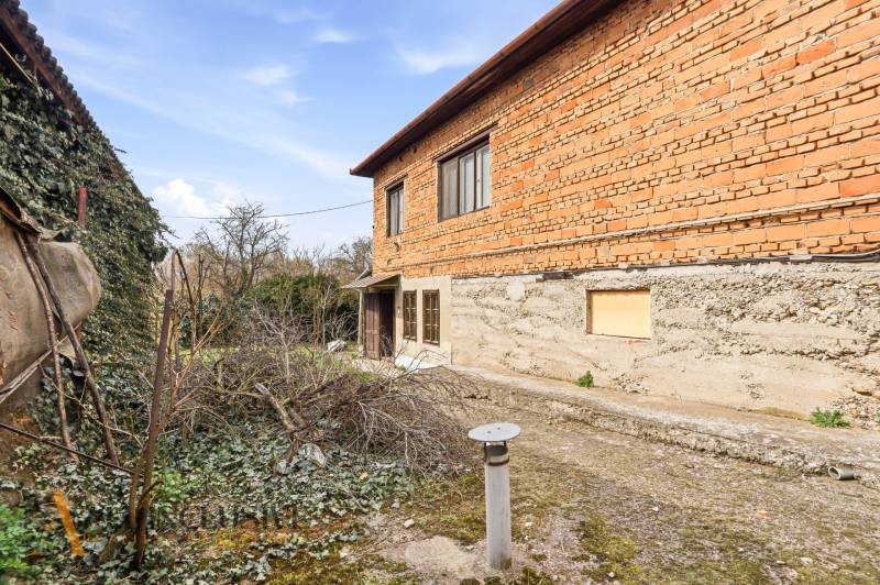 A family house in Malá nad Hronom, brick facade, covered with ivy, rustic character.