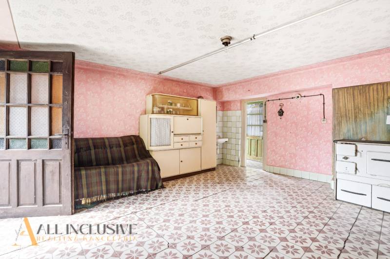 Living room in a family house with a vintage cabinet, sofa, and patterned floor.