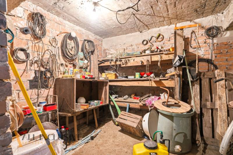 Workshop in a family house with tools and materials, brick walls.