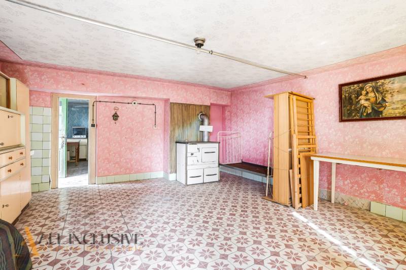 A room in a family house with a traditional stove and colorful tiled floor.