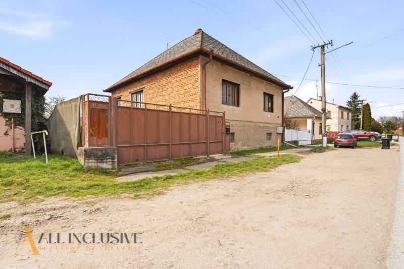 A family house in the village of Malá nad Hronom with a gate and a stone fence.