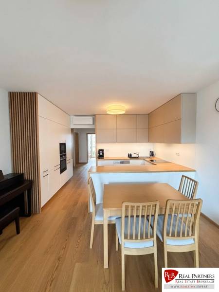 A kitchen with a dining table; floor with wooden decor; 3-room apartment.