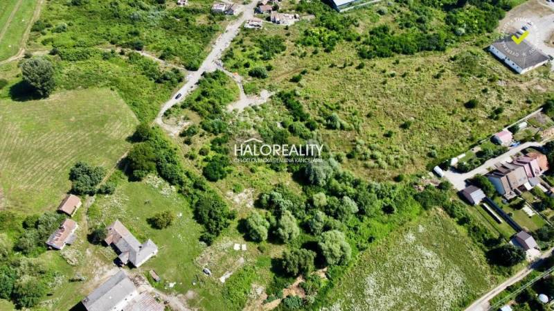 Aerial view of residential plots in Tornaľa, surrounded by greenery and buildings.