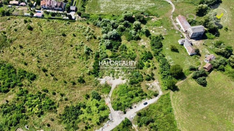 Aerial view of land - housing in Tornaľa with greenery and buildings in the surroundings.