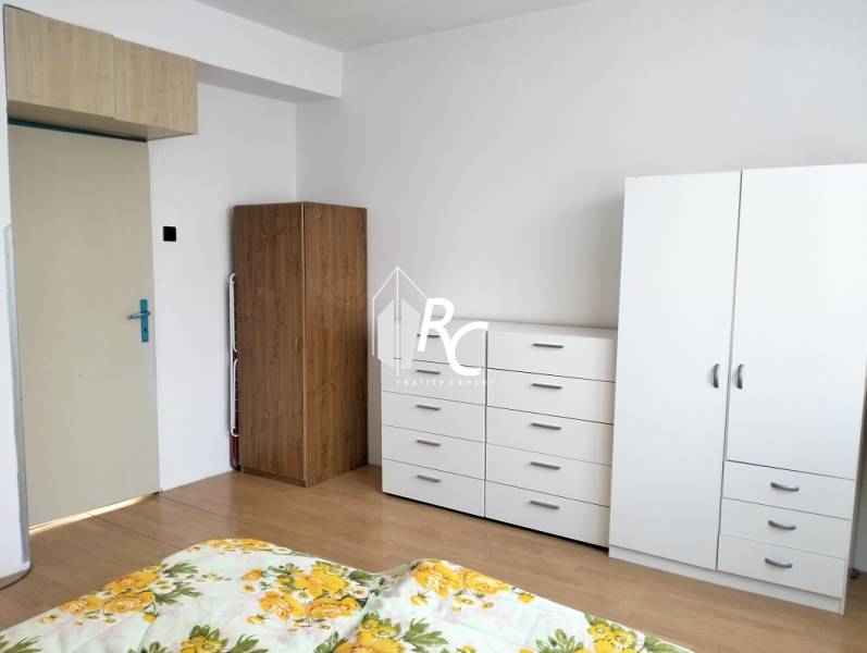 White wardrobe and dresser with wood decor in a 2-room apartment.