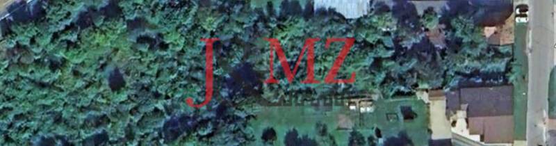 Aerial view of a plot of land, overgrown with trees, ideal for plots and housing.