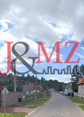 A view of a street with family houses in Levice suitable for residential land.