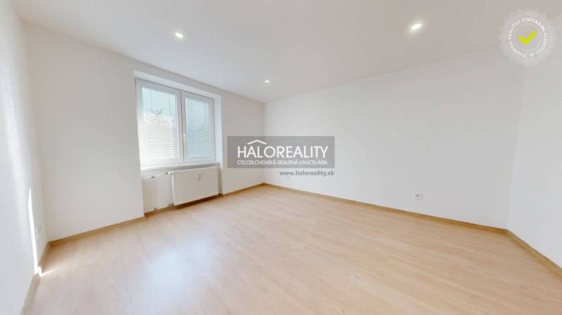 A spacious room with light walls and a wooden decor floor.