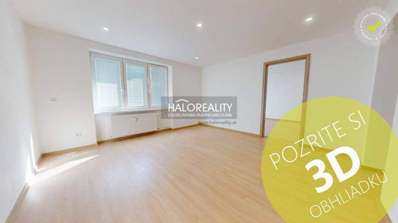Bright living room in a two-room apartment with wood-patterned flooring.