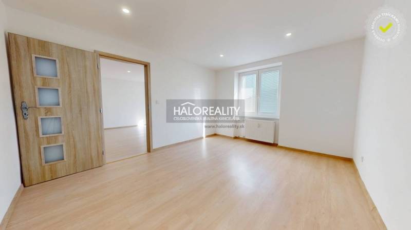 A room with a wooden decor floor in a 2-room apartment, a bright room with a window.