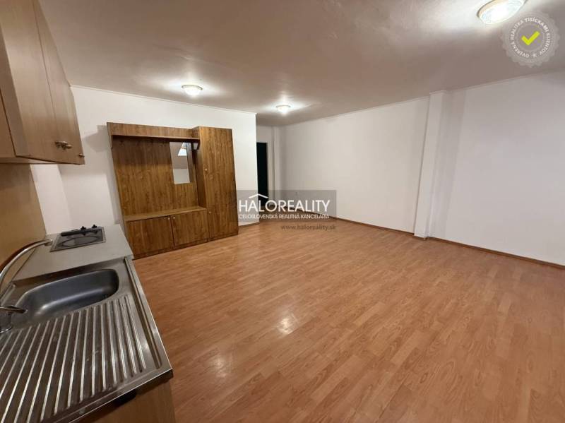 Studio apartment with a kitchenette and a wooden decor floor.
