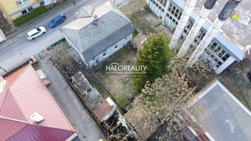 A family house in Rimavská Sobota with an asphalt road, an older roof, and a spacious yard.