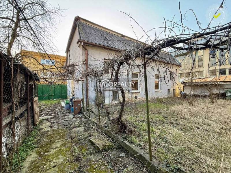 A family house in Rimavská Sobota with an unkempt garden and visible bare trees.