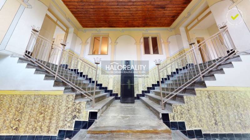 A staircase in a family house with decorative railings and painted elements on the walls.