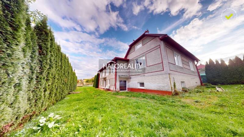 A family house in Hrachovo with a well-maintained lawn and a hedge.