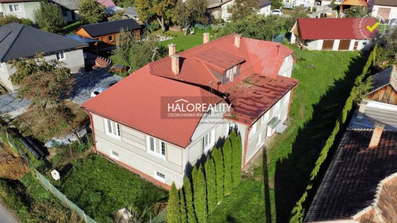 A family house in Hrachovo with a garden and a red metal roof.