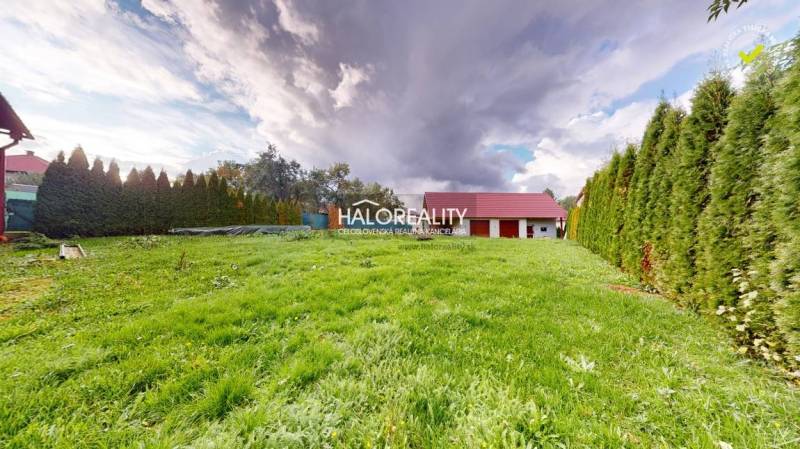 A garden at a family house in Hrachovo with a green lawn and a hedge.