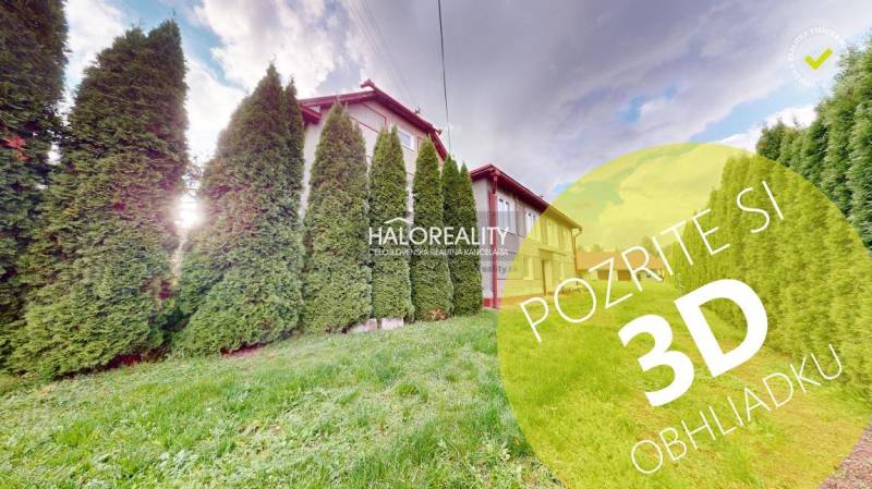 A family house in Hrachovo surrounded by conifers and lawn, sunny weather.