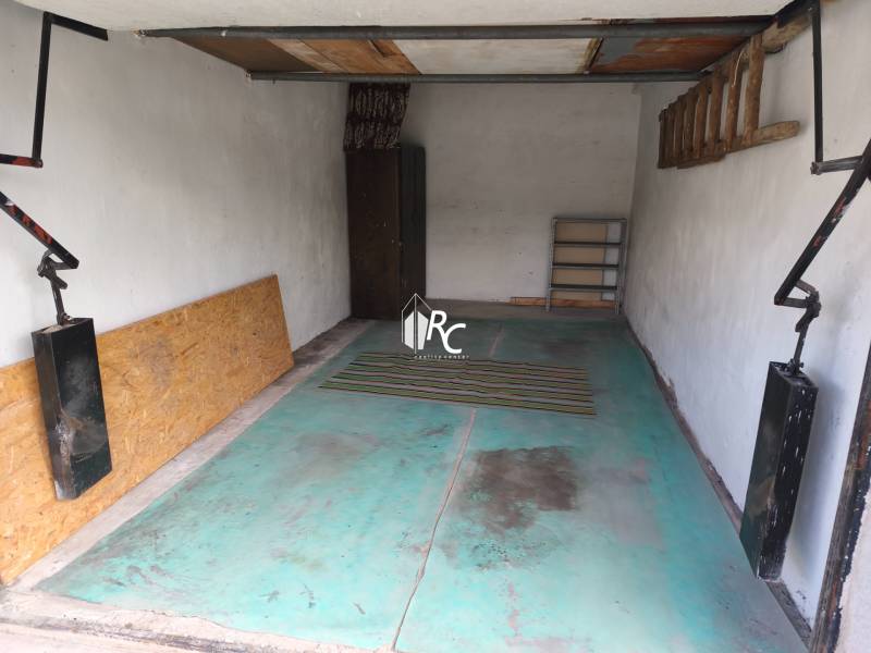 Garages on Kozmonautov Street in Martin with blue flooring and a shelf on the wall.