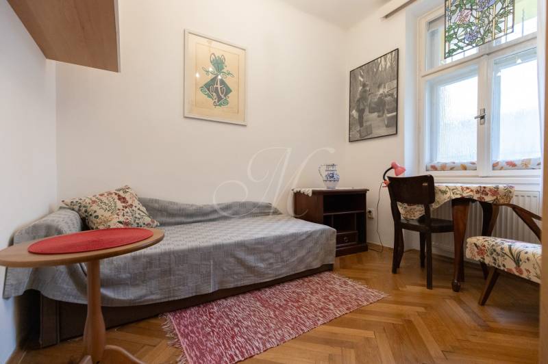 A room in a 3-bedroom apartment with decorative flooring, chairs, and a table.