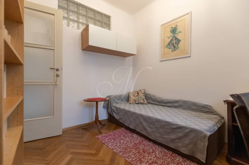A room in a 3-room apartment with a wooden decor floor and minimalist furniture.