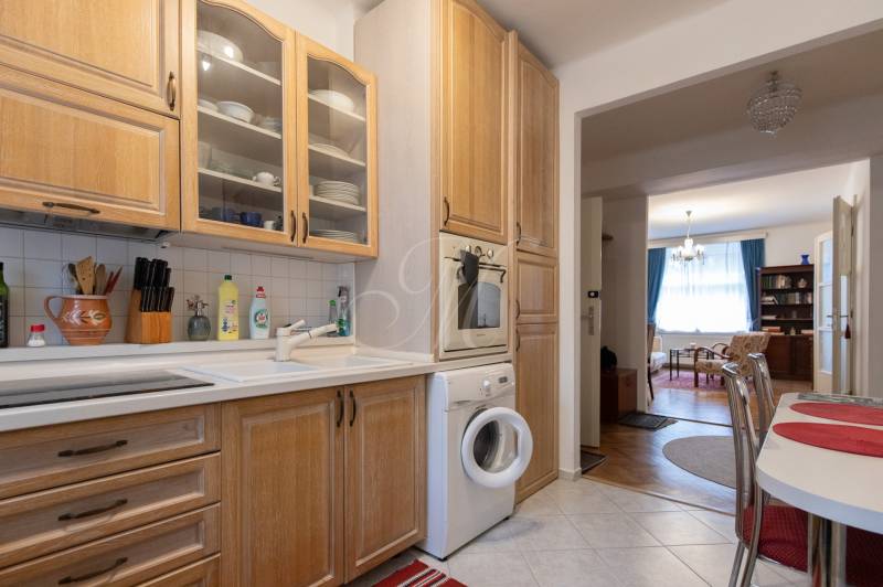 The kitchen of a 3-room apartment with wooden decor furniture and appliances.