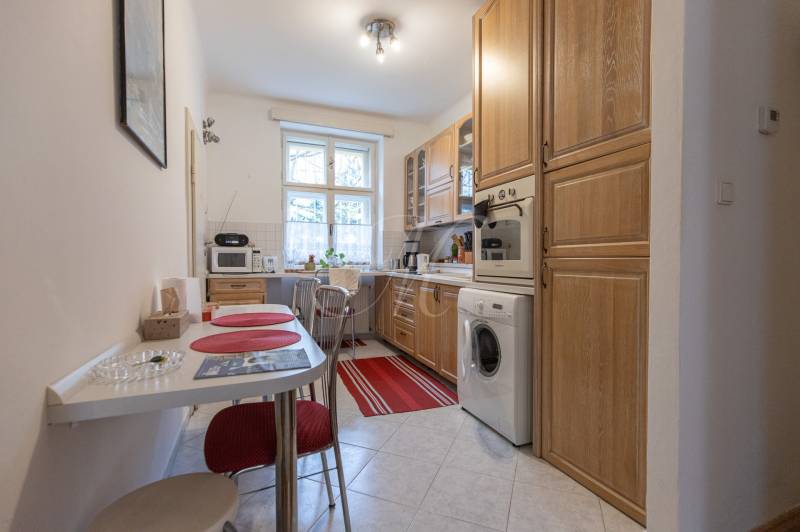 A kitchen in a 3-room apartment with a dining area, cabinets, and appliances.