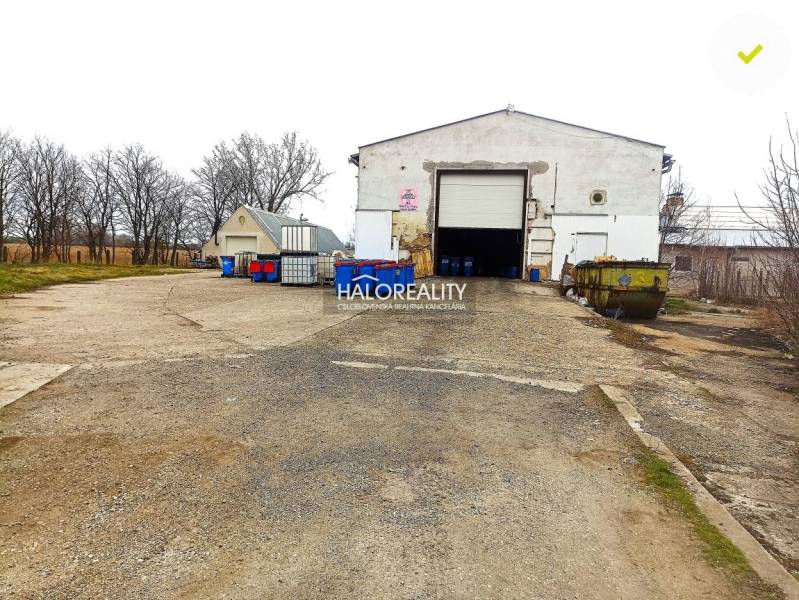 An industrial building suitable for business, outdoor area with blue containers.