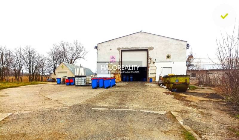 An industrial building with a dilapidated appearance and various colored containers in the office area.
