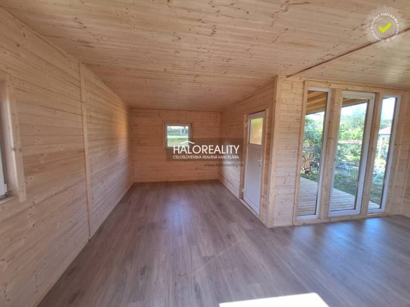 Interior of a wooden room with windows and a floor; Gardens.