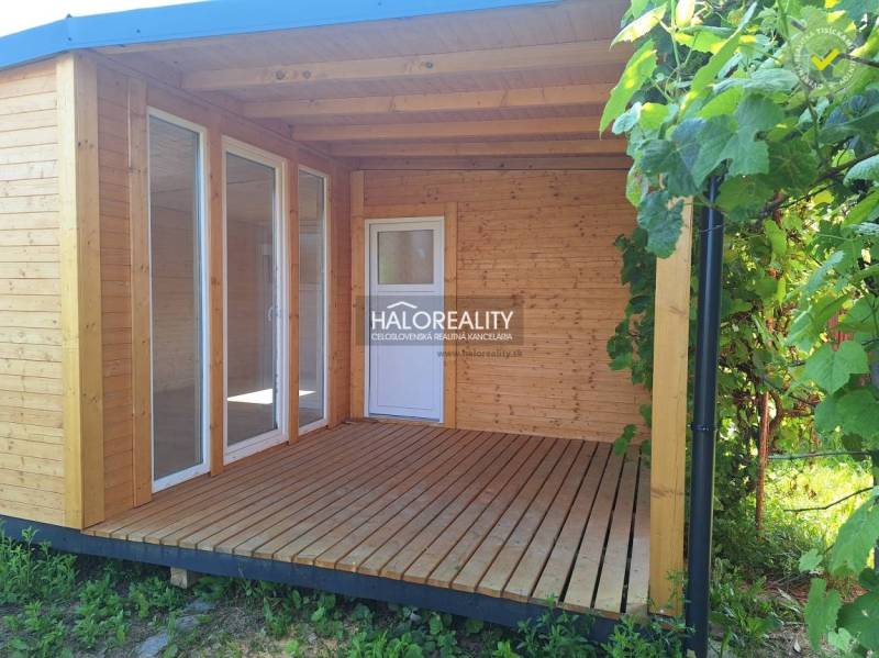 A wooden terrace by the house in the Gardens in Bojnice, surrounded by vines.