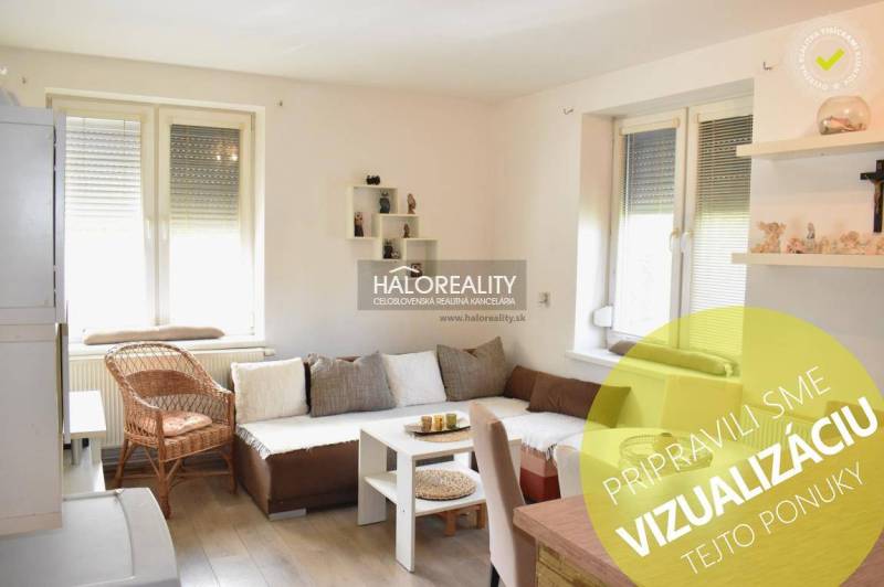 A bright living room with a sofa and a wood-patterned floor in a two-room apartment.